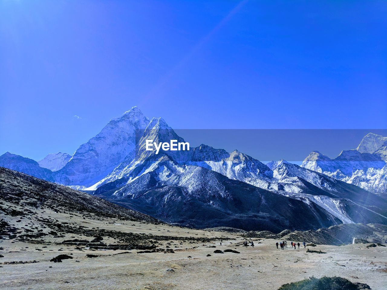 Scenic view of snowcapped mountains against clear blue sky