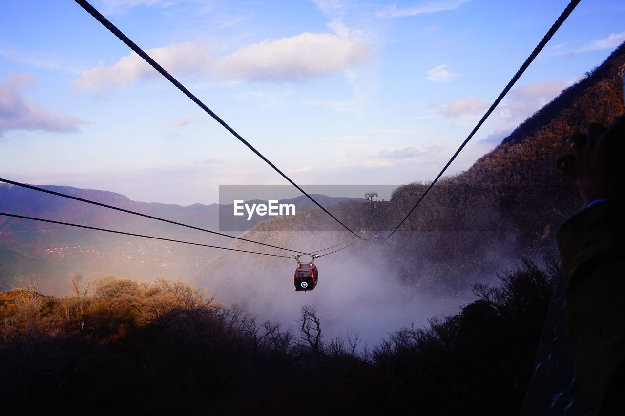 Low angle view of overhead cable car against sky