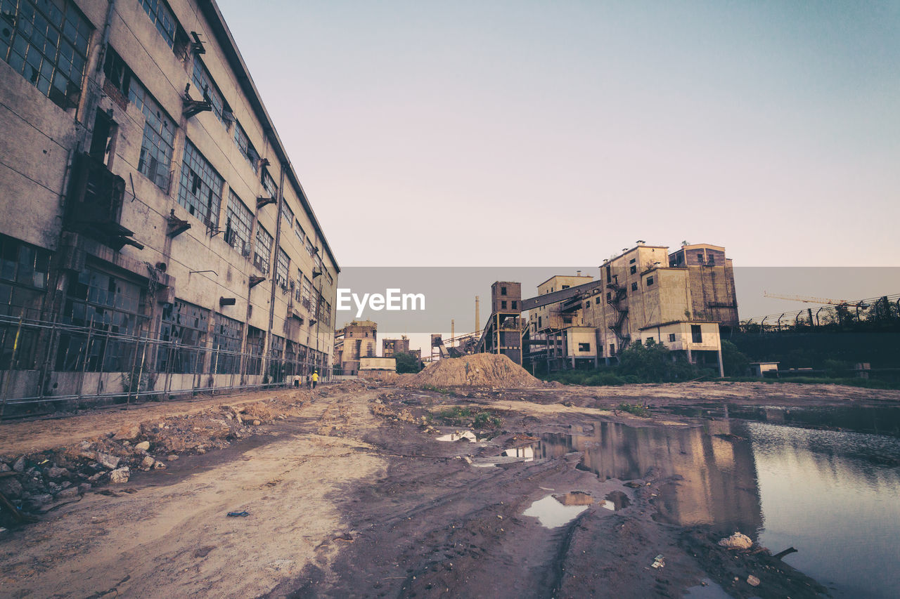 BUILDINGS BY STREET AGAINST CLEAR SKY