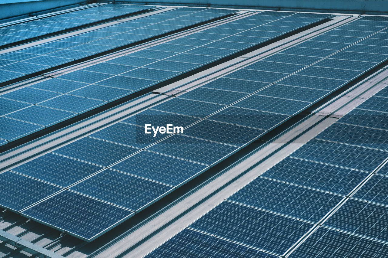 Many photo voltaic solar panels mounted of industrial building roof .