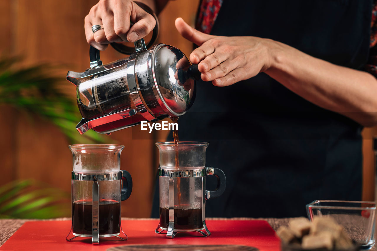 Midsection of woman making coffee in cafe