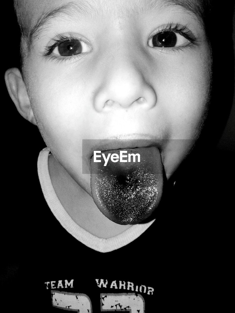 Close-up portrait of boy showing tongue