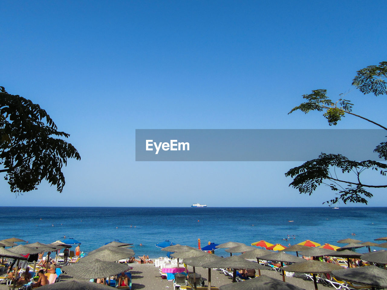 PEOPLE ON BEACH AGAINST BLUE SKY