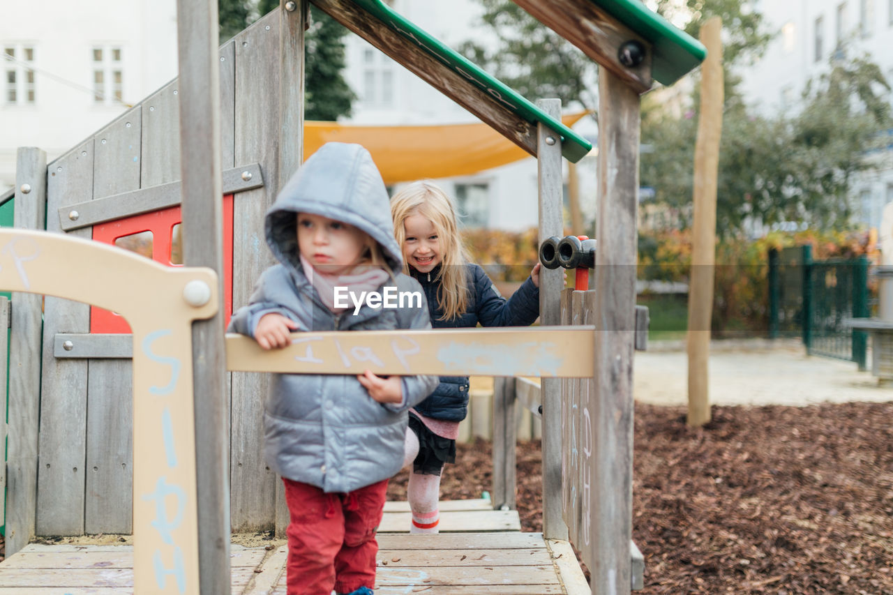 Cute sisters wearing warm clothing at playground