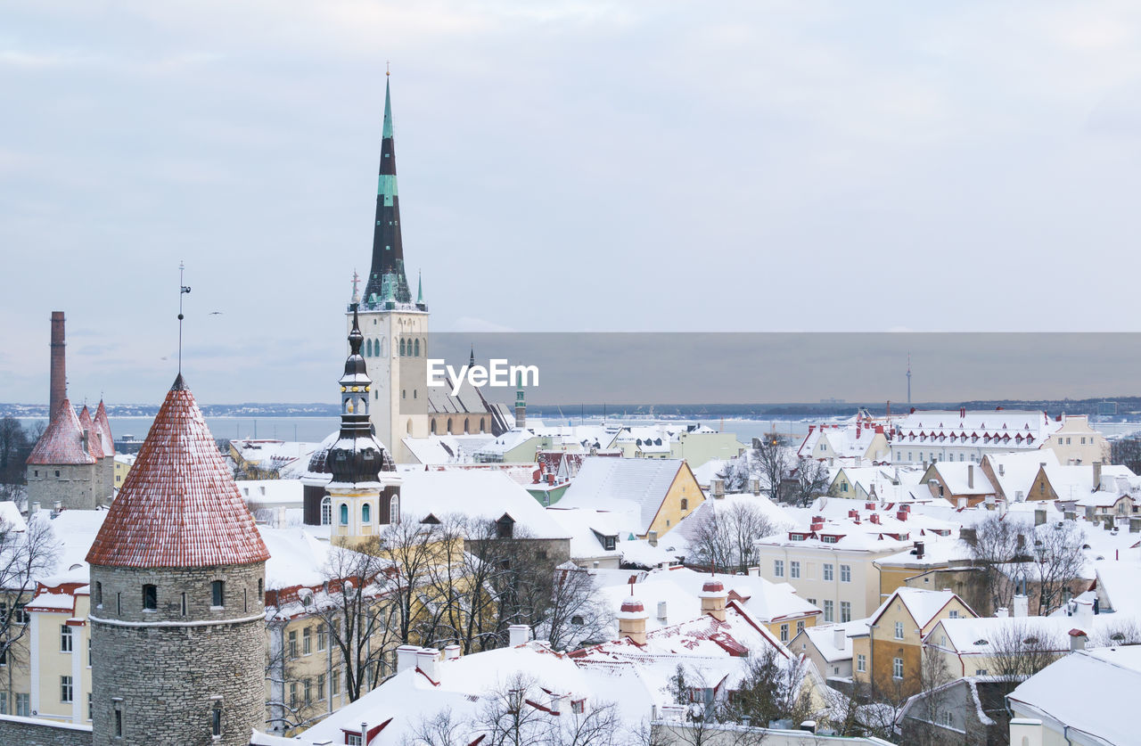 Snow covered city against sky