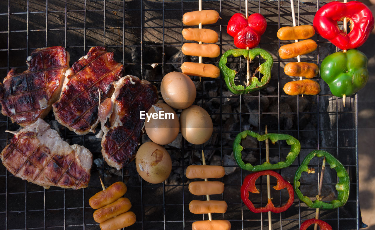 Directly above shot of meat with vegetables and eggs on barbecue grill