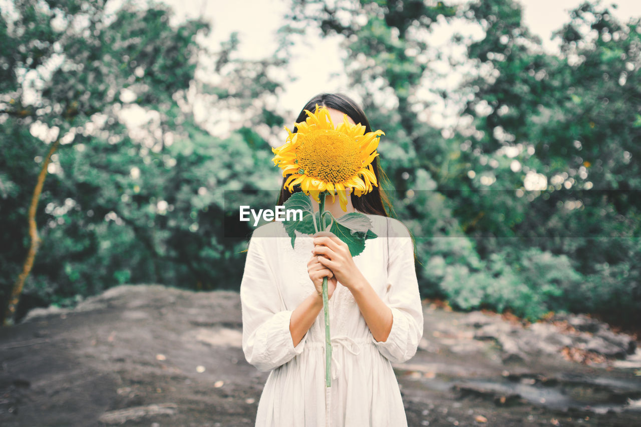 GIRL HOLDING YELLOW FLOWER