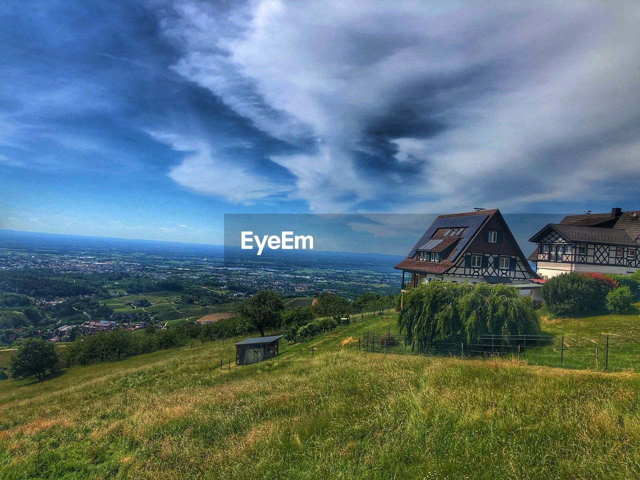 Scenic view of trees and houses against sky