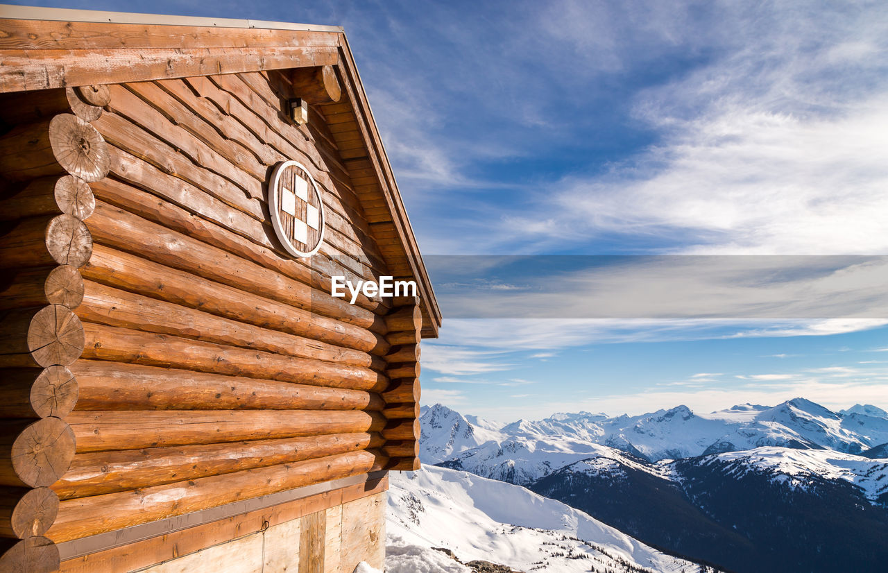 BUILT STRUCTURE ON SNOWCAPPED MOUNTAINS AGAINST SKY