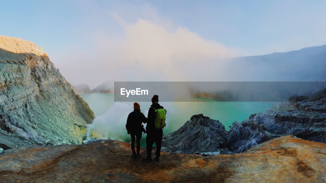 Rear view of man and woman hiking at ijen