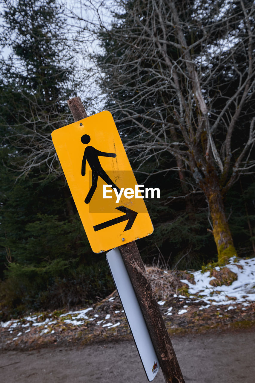 Yellow sign showing a walking man and an arrow