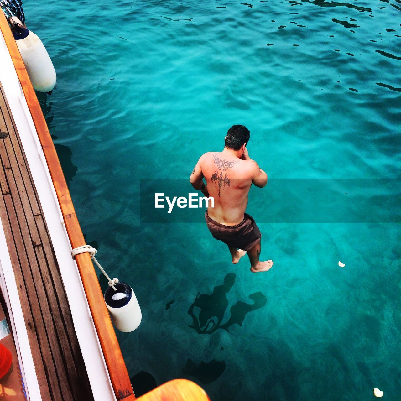 High angle view of man diving into sea from boat