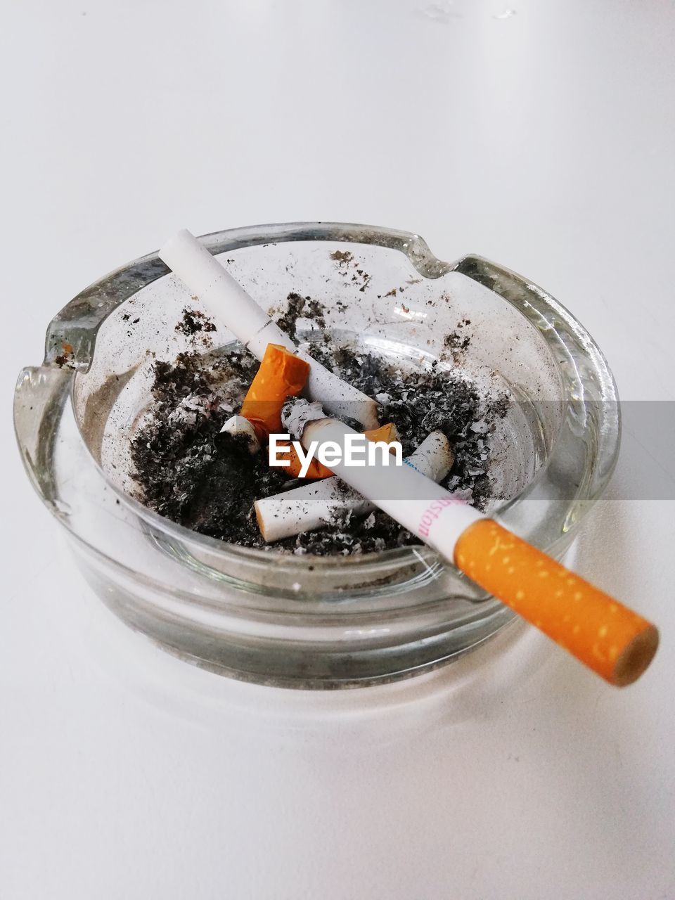 CLOSE-UP OF CIGARETTE SMOKING IN CONTAINER