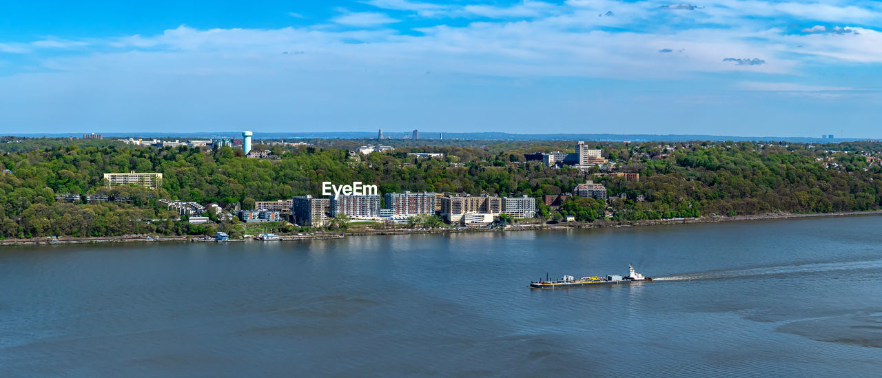 Scenic view of sea by buildings against sky