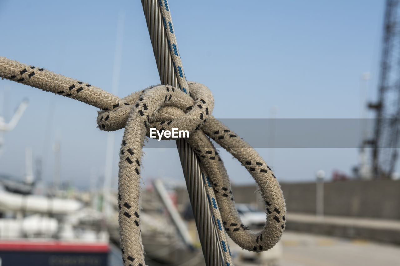 CLOSE-UP OF ROPE TIED ON SAILBOAT