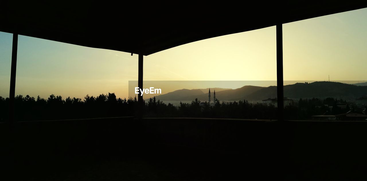SCENIC VIEW OF SILHOUETTE MOUNTAINS AGAINST SKY AT SUNSET