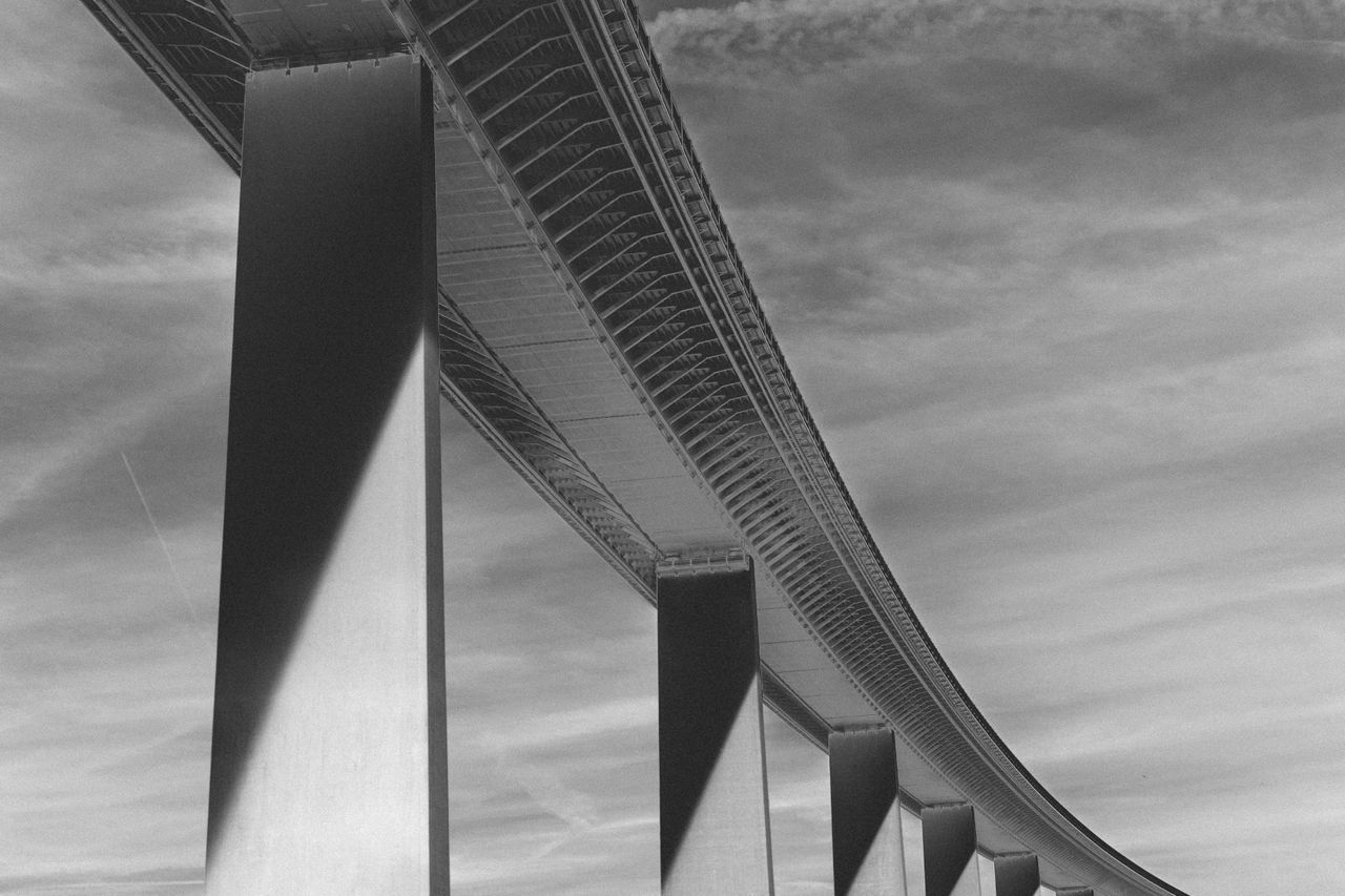 Low angle view of bridge against cloudy sky