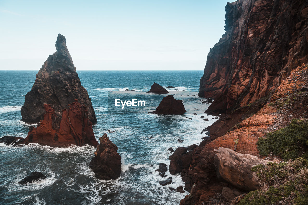 Rocks by sea against sky