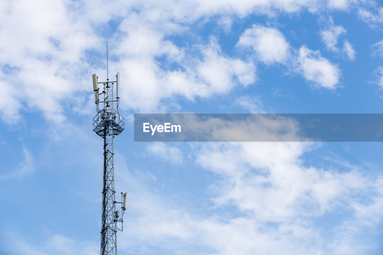 Low angle view of communications tower against cloudy sky