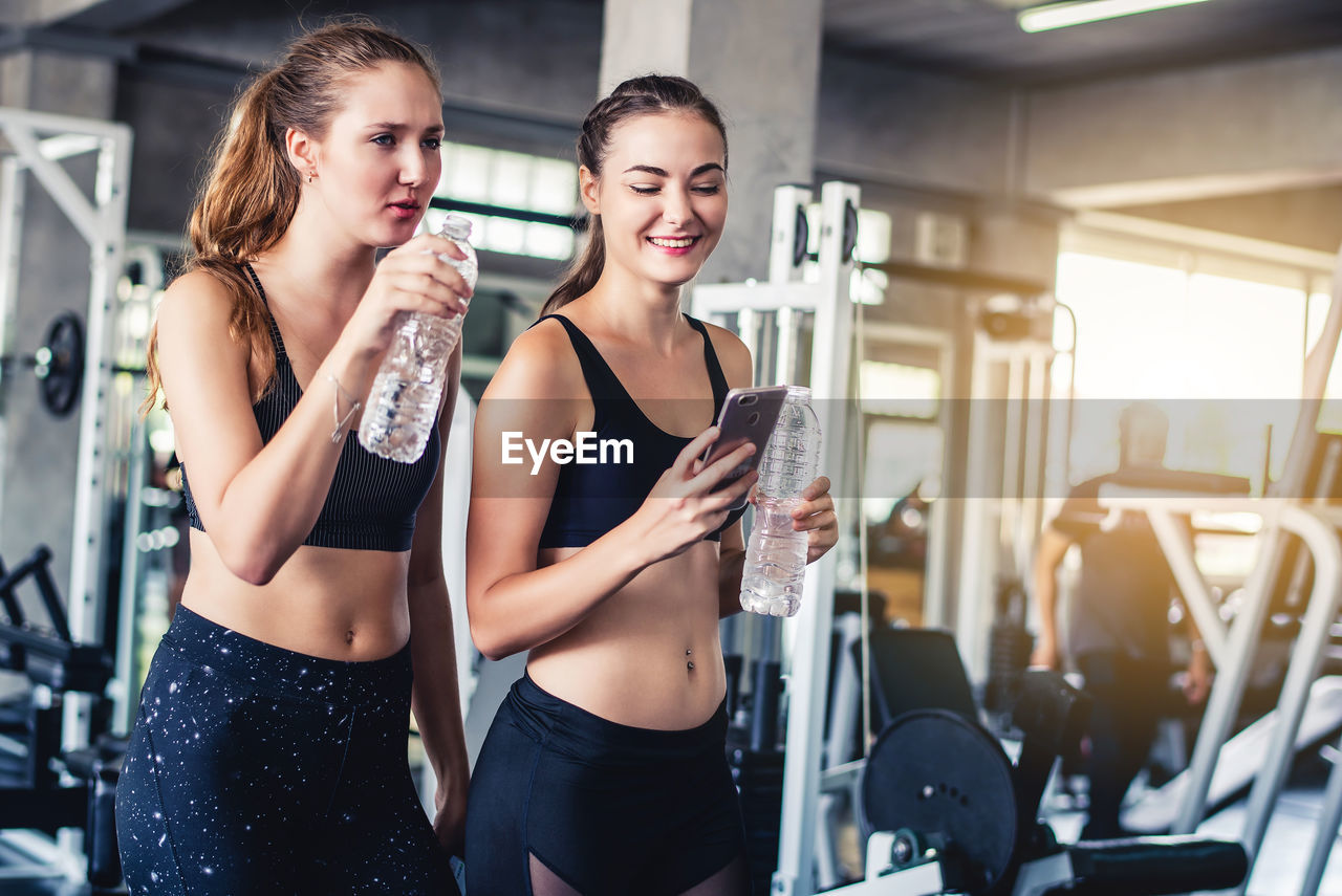 Female friends talking while standing in gym