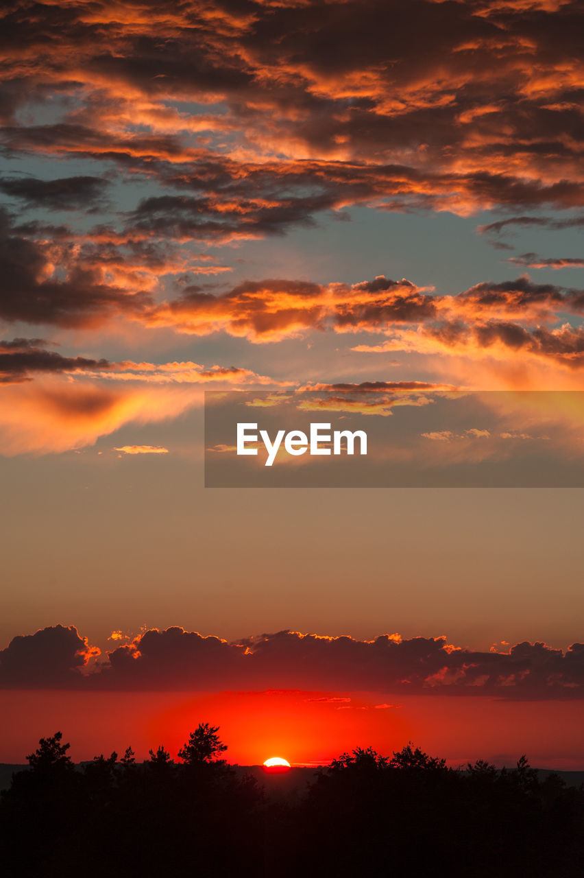 Scenic view of silhouette landscape against orange sky