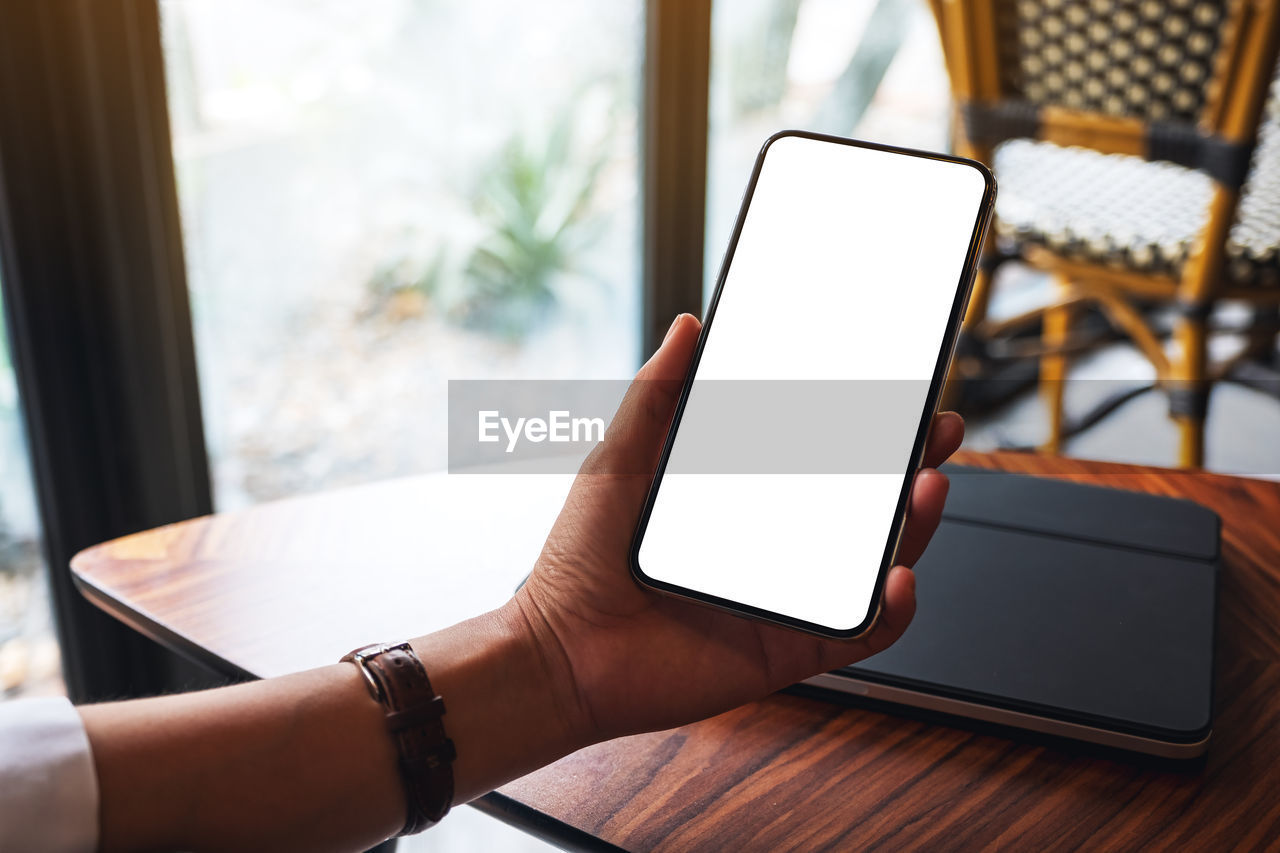 wireless technology, technology, communication, adult, computer, digital tablet, internet, portable information device, one person, smartphone, table, indoors, business, computer network, hand, portability, mobile phone, women, screen, furniture, window, lifestyles, laptop, using computer, copy space, business finance and industry, touch screen, relaxation, young adult, holding, desk, telephone, home interior, day, activity, office