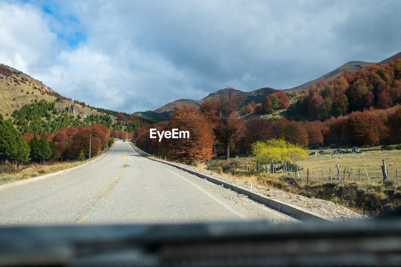 empty road amidst mountains against sky