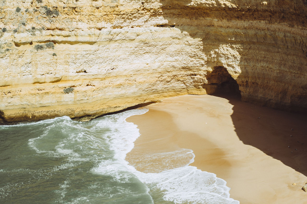 High angle view of shore by rock formation 