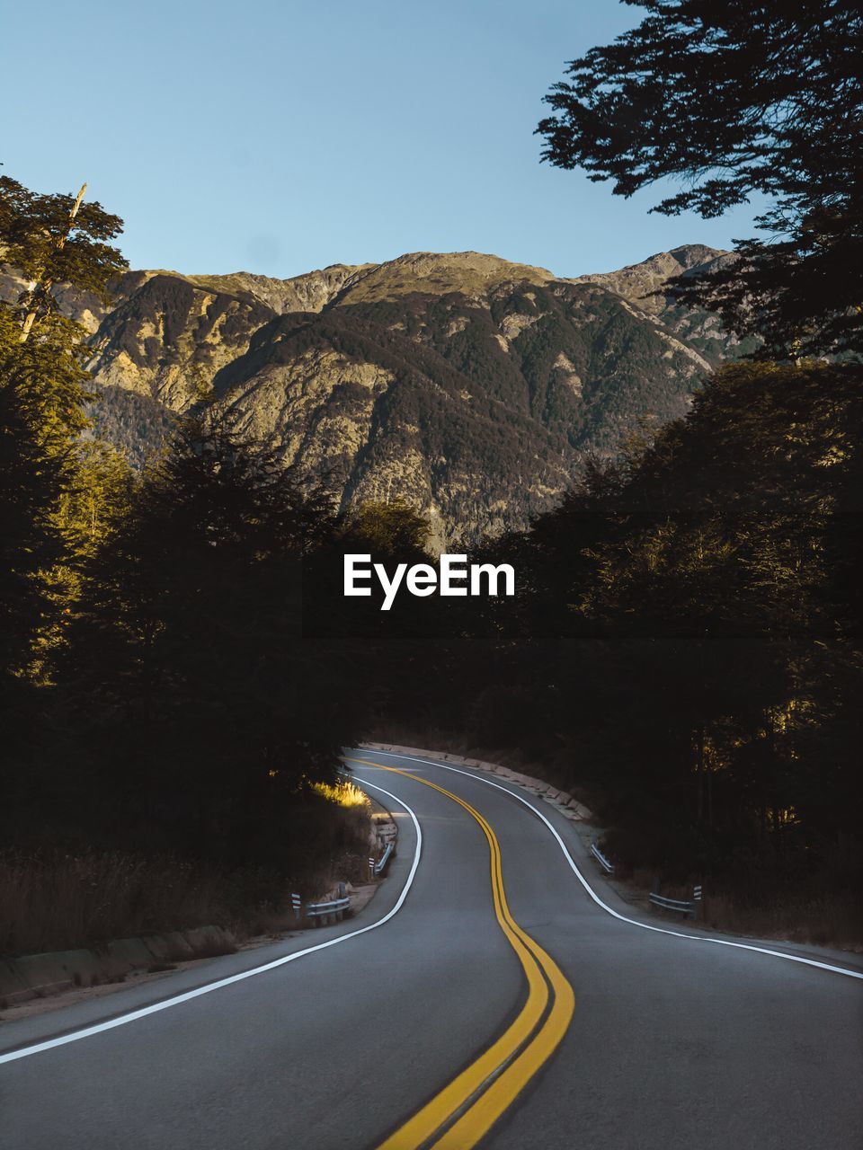 Country road by mountain against sky