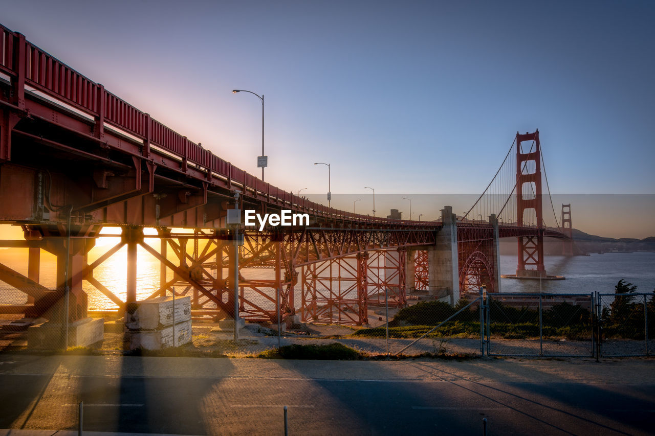 Bridge over river in city against sky