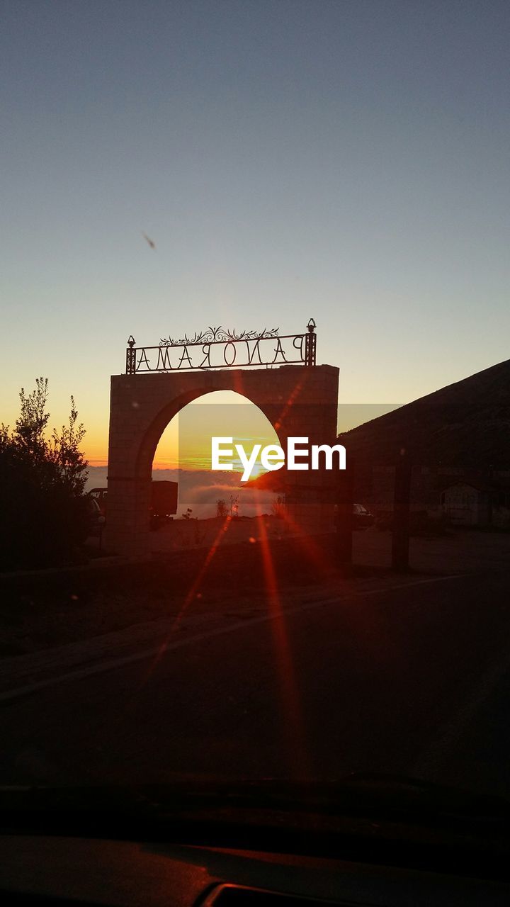 Car on road against clear sky during sunset