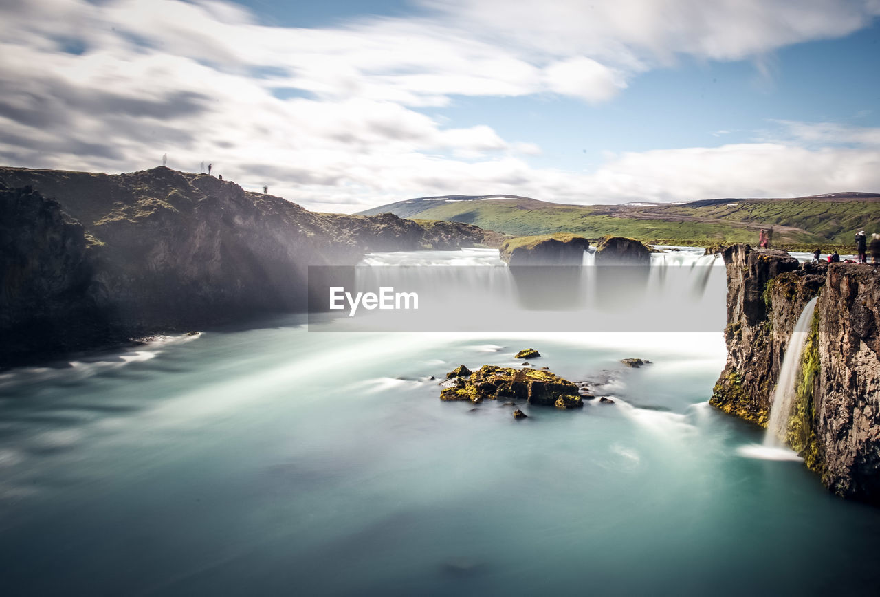 SCENIC VIEW OF WATERFALL AGAINST SKY