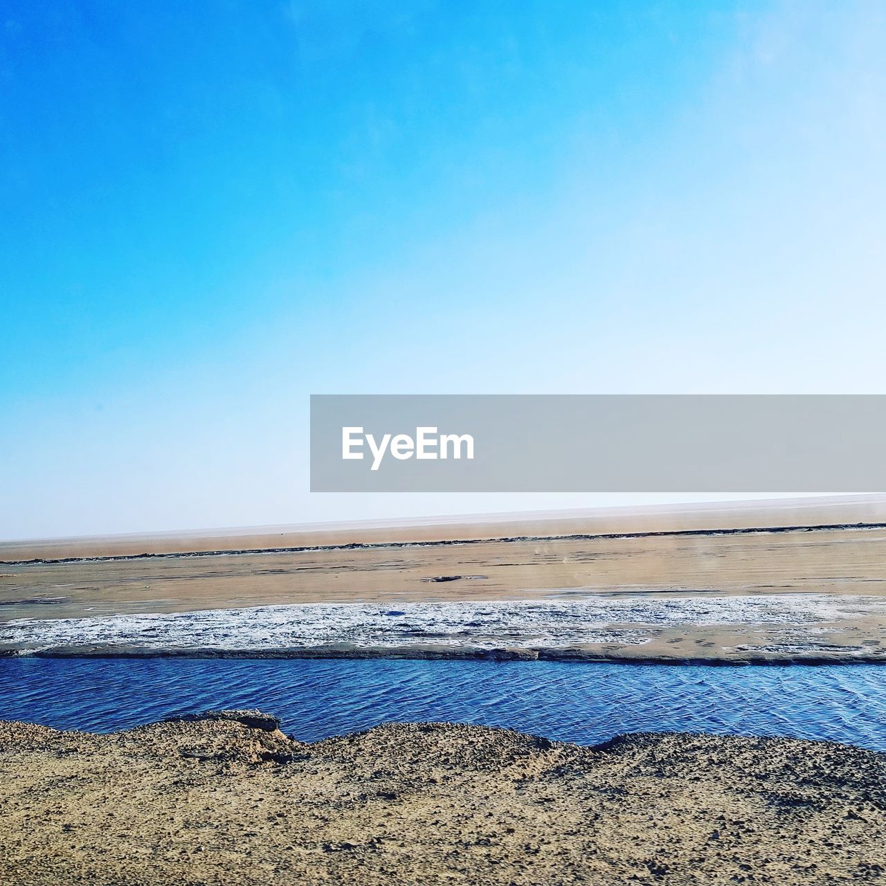 SCENIC VIEW OF BEACH AGAINST BLUE SKY