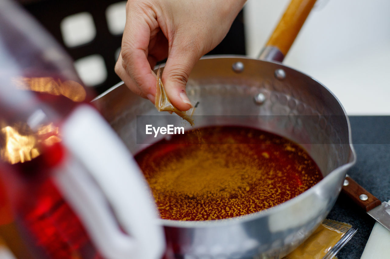 CLOSE-UP OF PERSON PREPARING MEAT