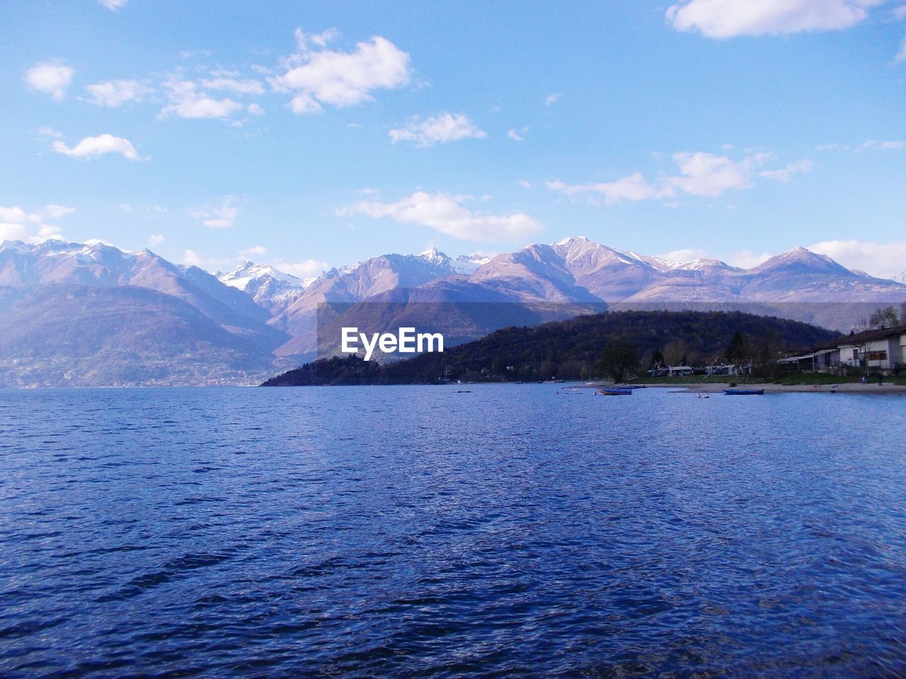 Scenic view of mountains and sea against cloudy sky