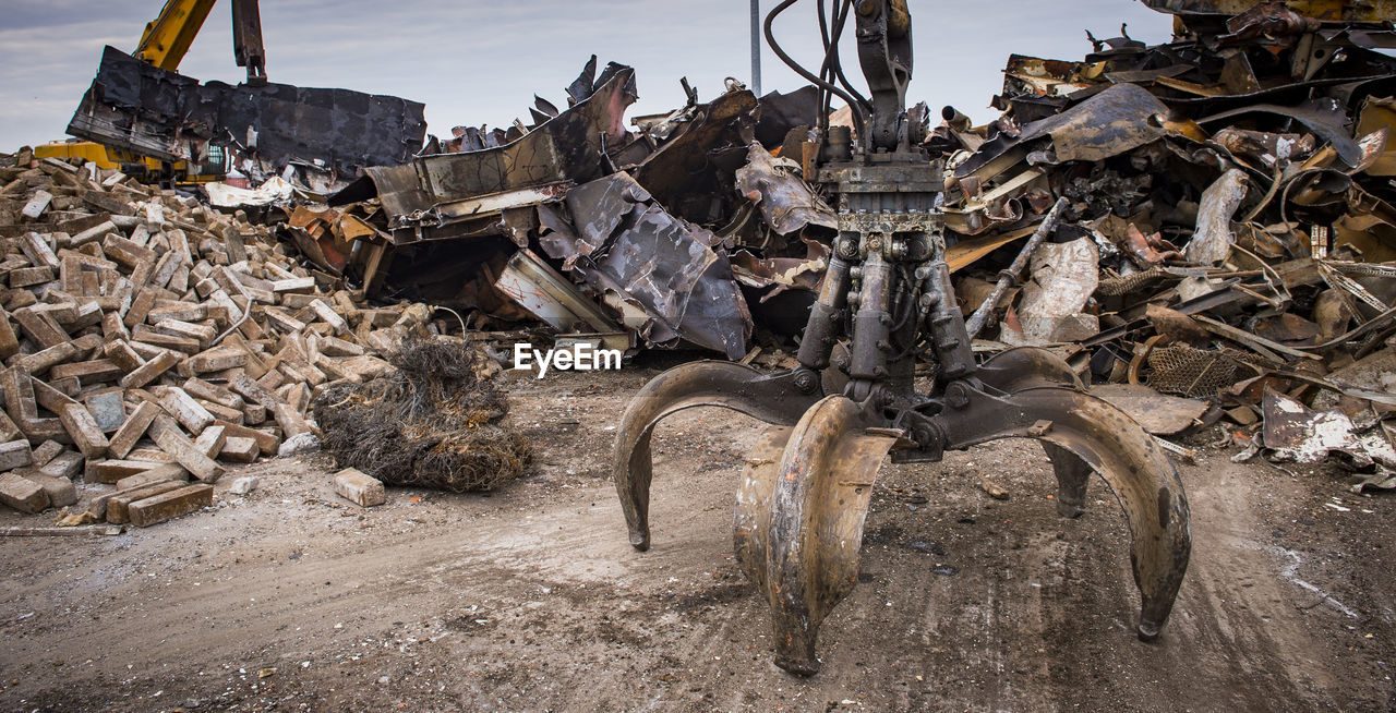 STACK OF GARBAGE ON FIELD BY METAL FENCE