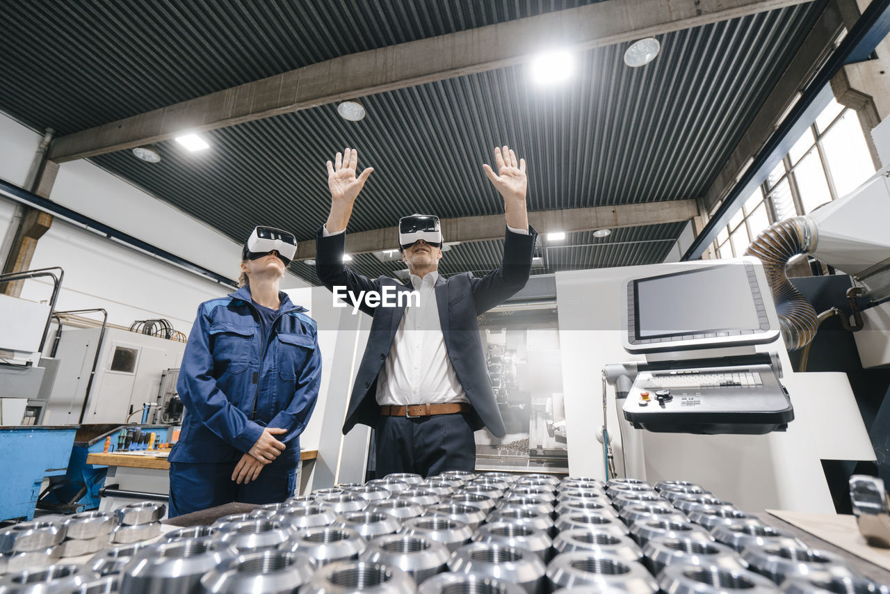 Businessman and skilled worker in high tech enterprise, using vr glasses