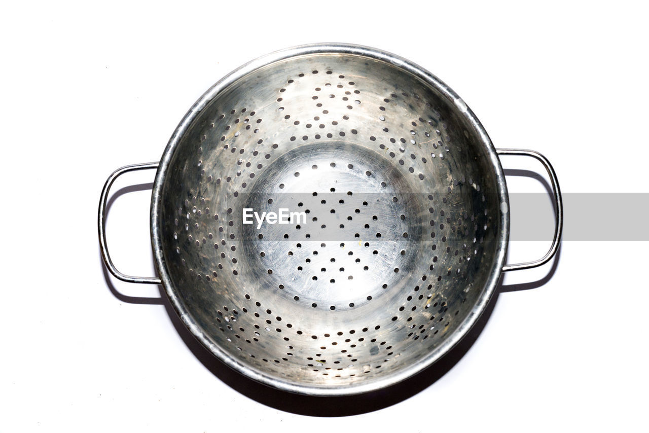 Close-up of colander over white background