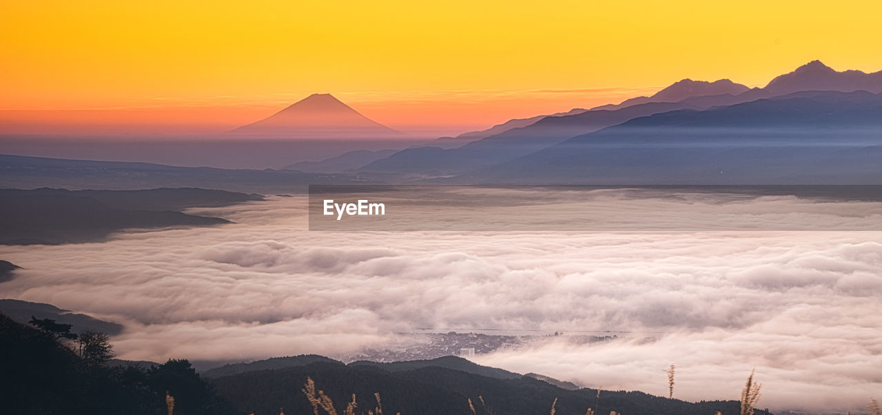 Scenic view of snowcapped mountains against sky during sunset