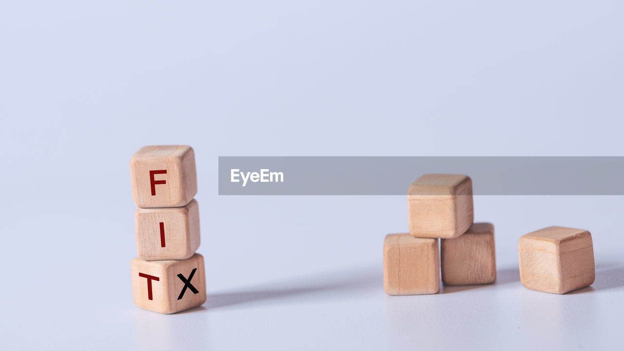 Hand holding dice with text for illustration of fit and fix words