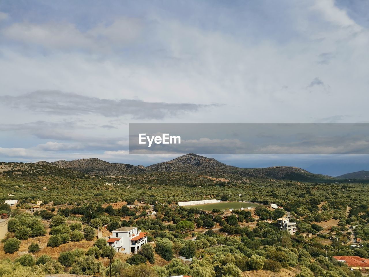 Scenic view of townscape and mountains against sky