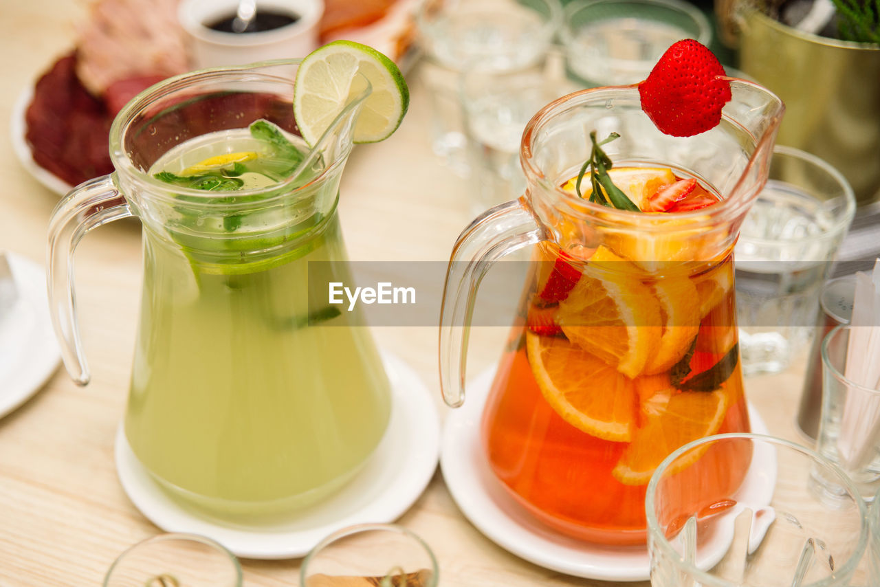 food and drink, food, fruit, healthy eating, soft drink, drink, refreshment, glass, wellbeing, citrus fruit, drinking glass, household equipment, freshness, meal, orange color, indoors, produce, jar, container, lifestyles, table, pitcher - jug, herb, alcoholic beverage, juice, high angle view, vegetable, crockery