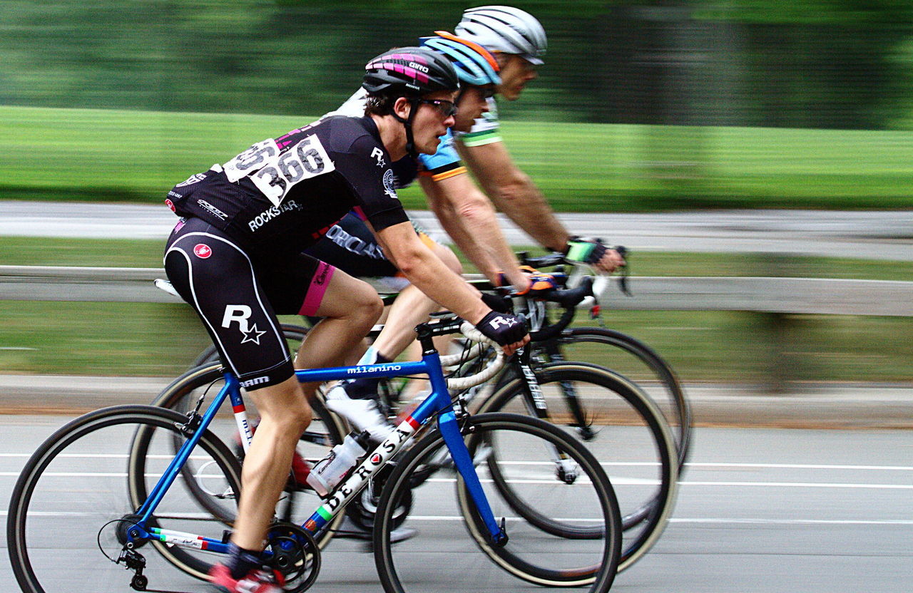 FULL LENGTH OF MAN RIDING BICYCLE ON STREET