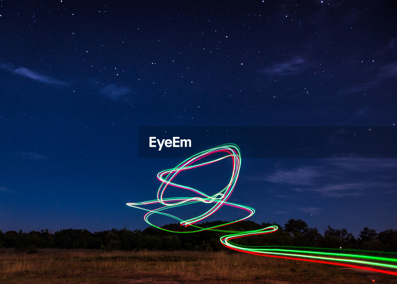 LIGHT PAINTING ON FIELD AGAINST SKY