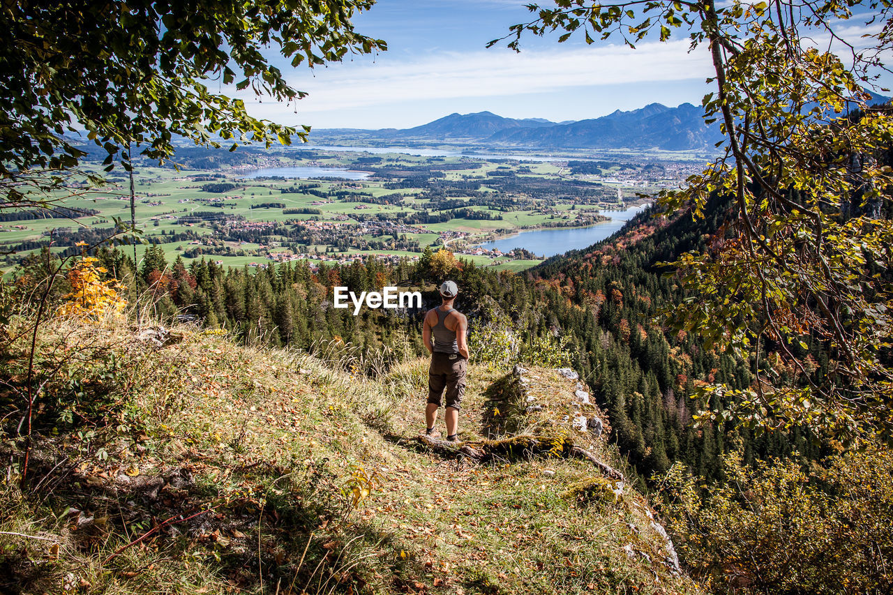Rear view of man looking at view while standing on mountain