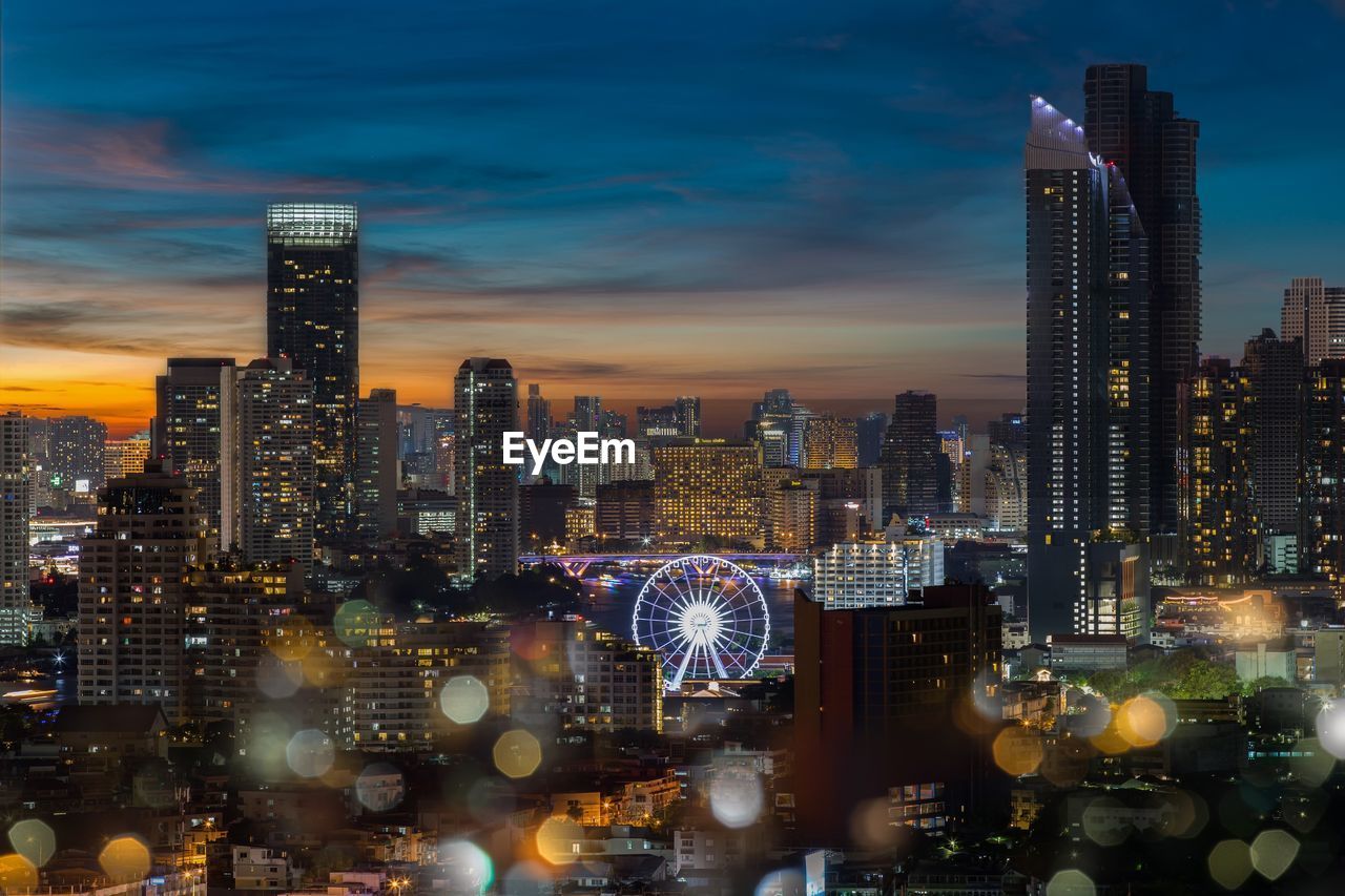 Illuminated buildings in city against sky at night