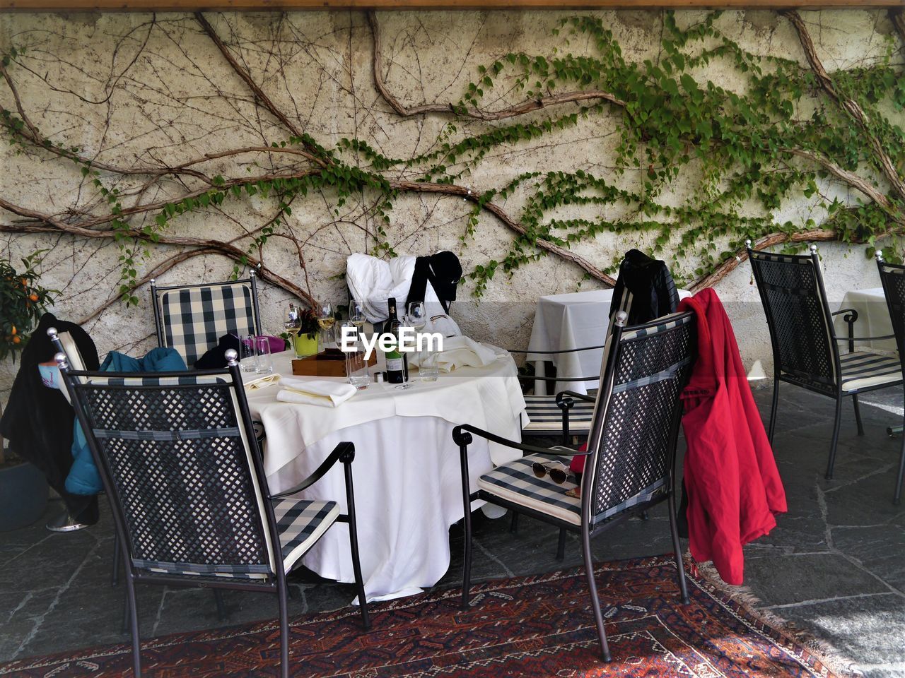 Chairs and tables at sidewalk cafe against clear sky