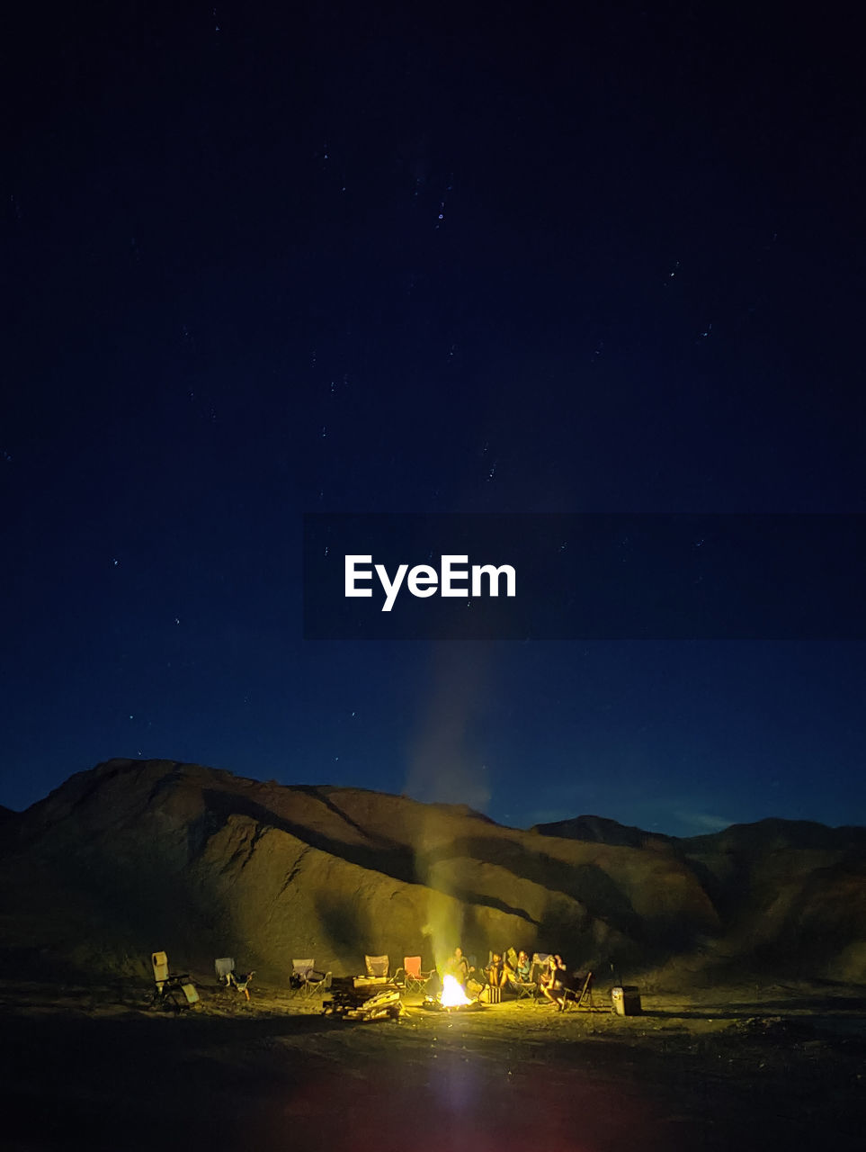 Scenic view of the mountain against the sky at night with campfire