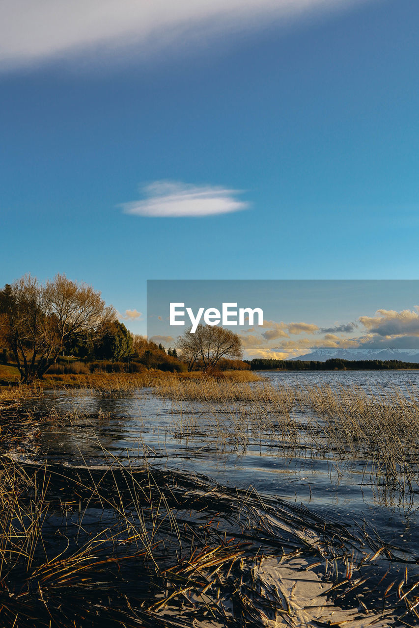 Scenic view of river against blue sky