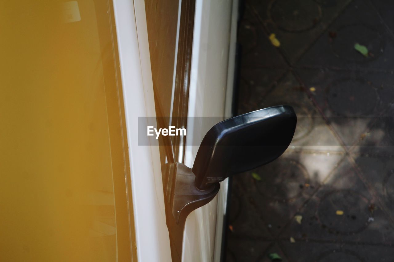 High angle view of car side-view mirror on footpath